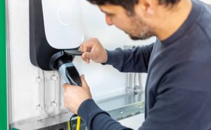 EV charging infrastructure with a driver connecting cable.