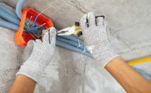 An electrician installing wiring at a construction site during a home renovation