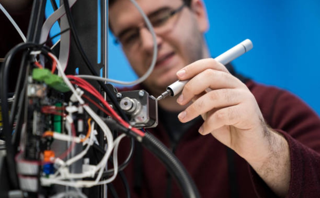 Technician removing an electronic control board for repair.