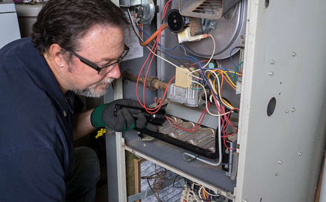 Professional doing preventative maintenance on a home furnace