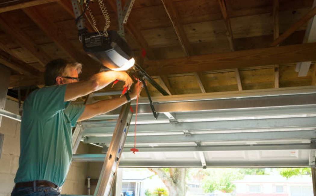 A technician repairing a professional automatic garage door opener in a home garage.