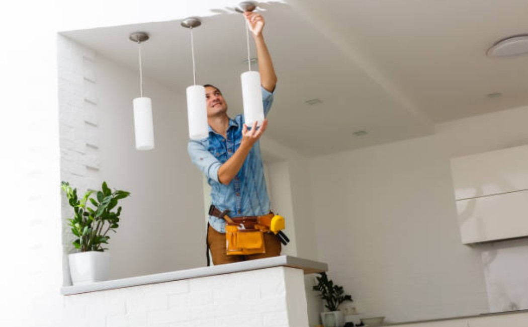 Professional electrician fixing a ceiling light installation
