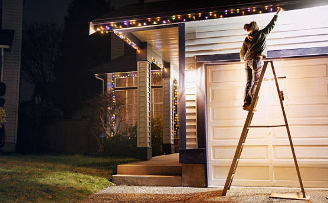 Nighttime Christmas light setup on residential roof