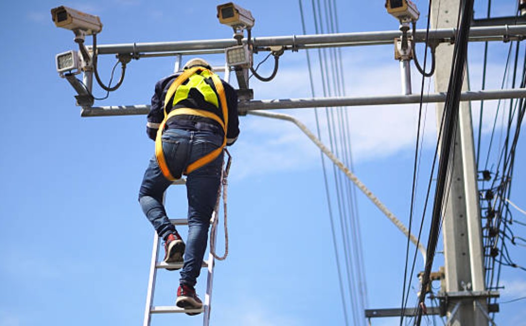 Electrician and engineer inspecting CCTV installation on a site
