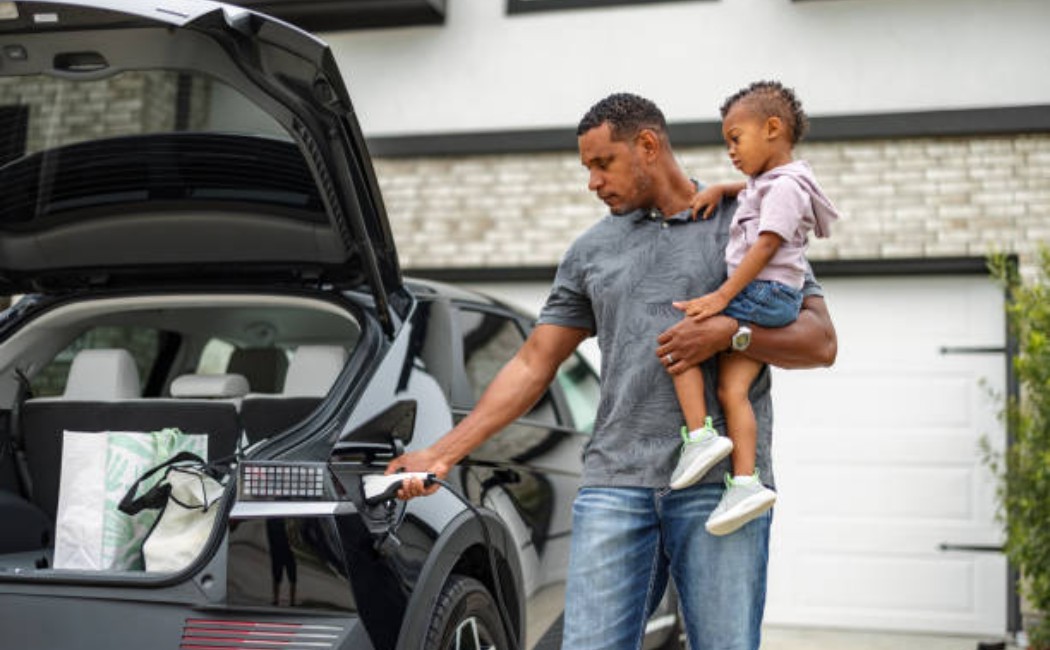 Man charging electric vehicle using home EV’s charging services