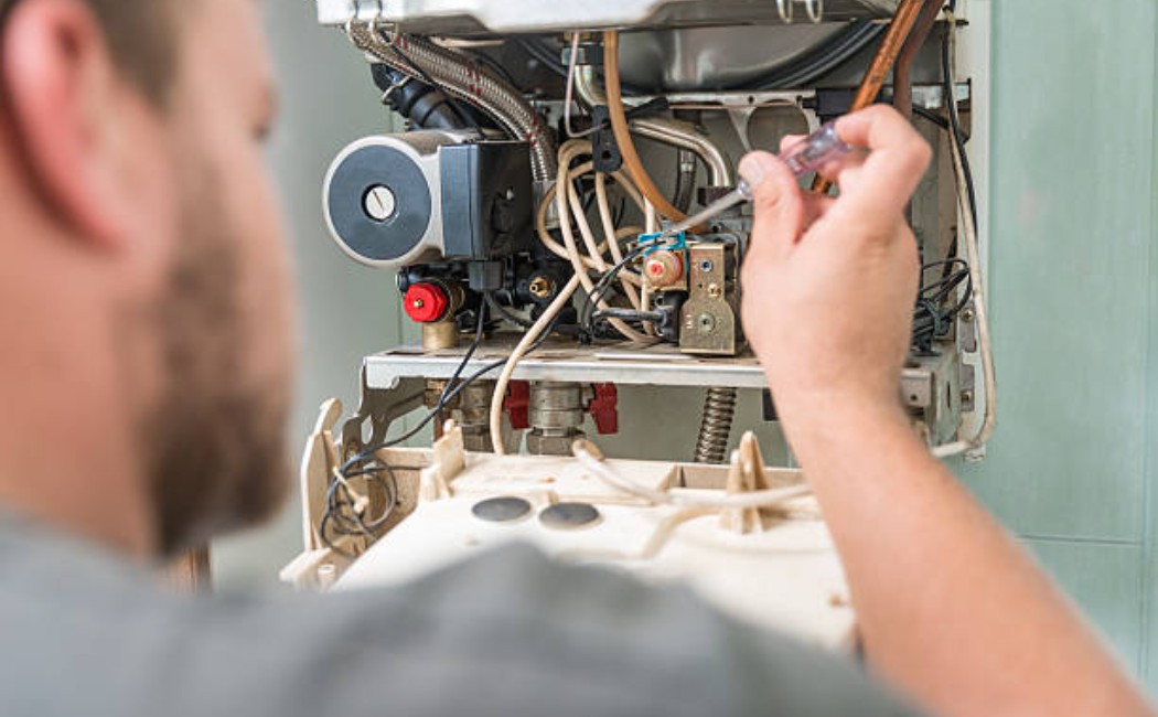 Professional servicing a home gas furnace to ensure proper heating