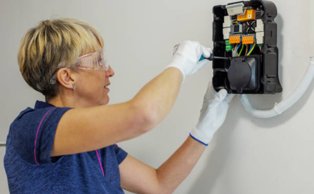Female electrician installing a home EV charger
